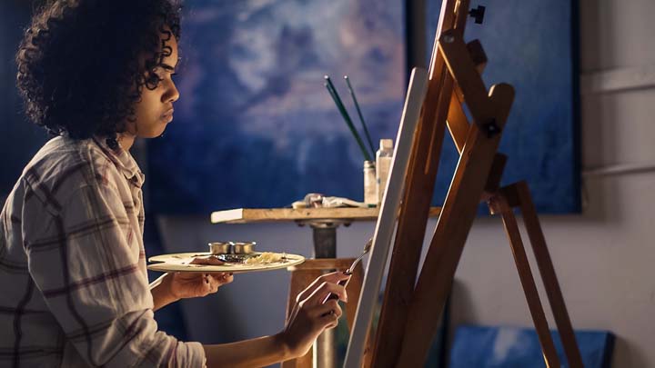 A teenage girl painting a picture