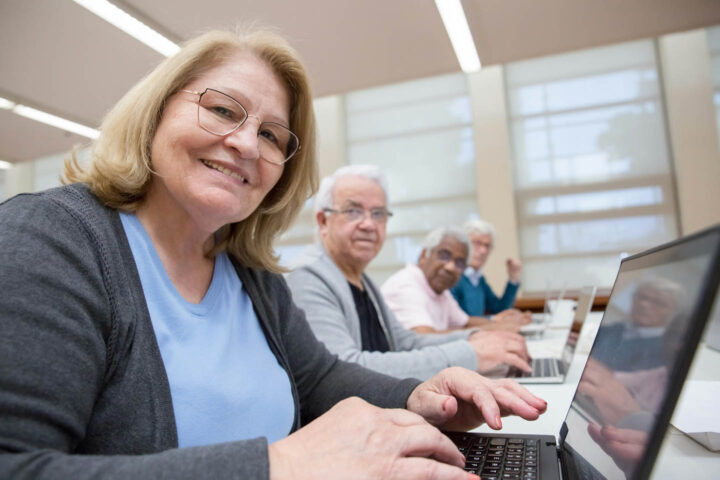 A group of seniors learning to handle a computer