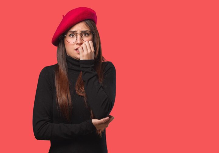 A nervous woman biting on her fingernails