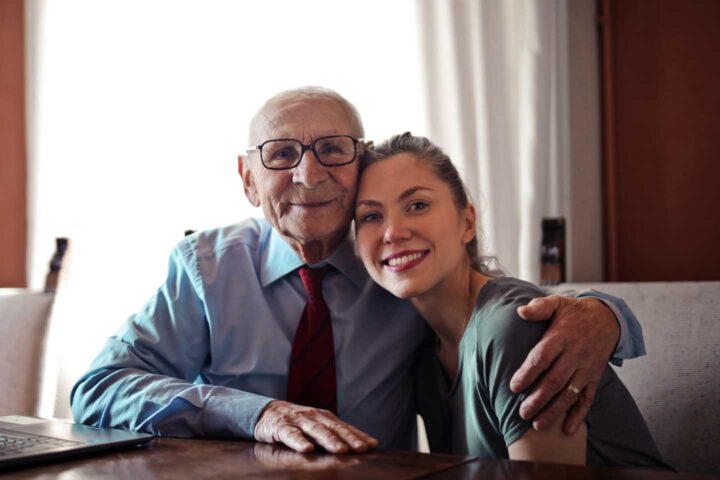 An elderly man receiving a visit from his daughter